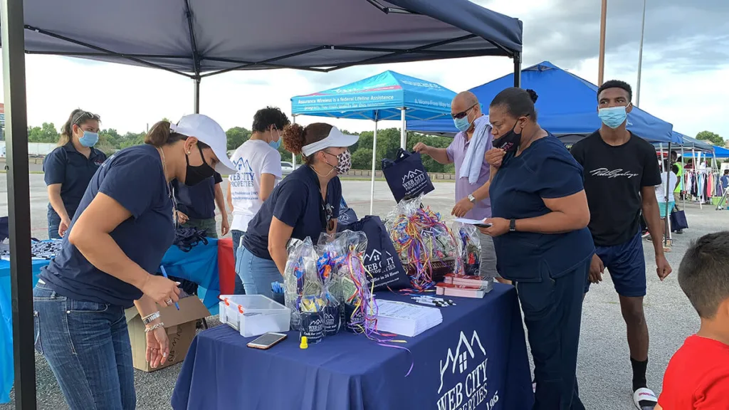 Web City Properties volunteers handing out supplies to families at a community outreach event